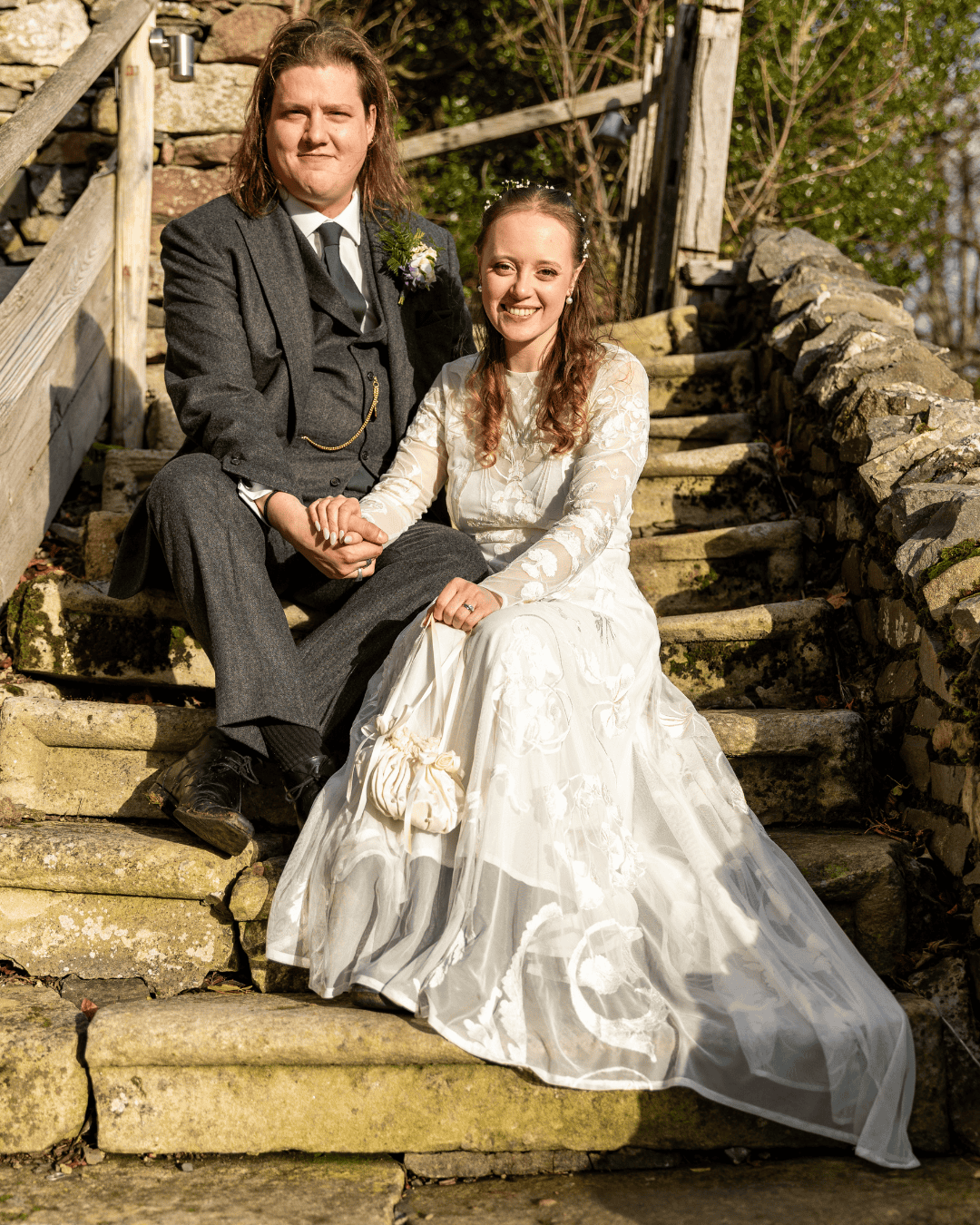 Bride and groom sitting on rustic stone steps