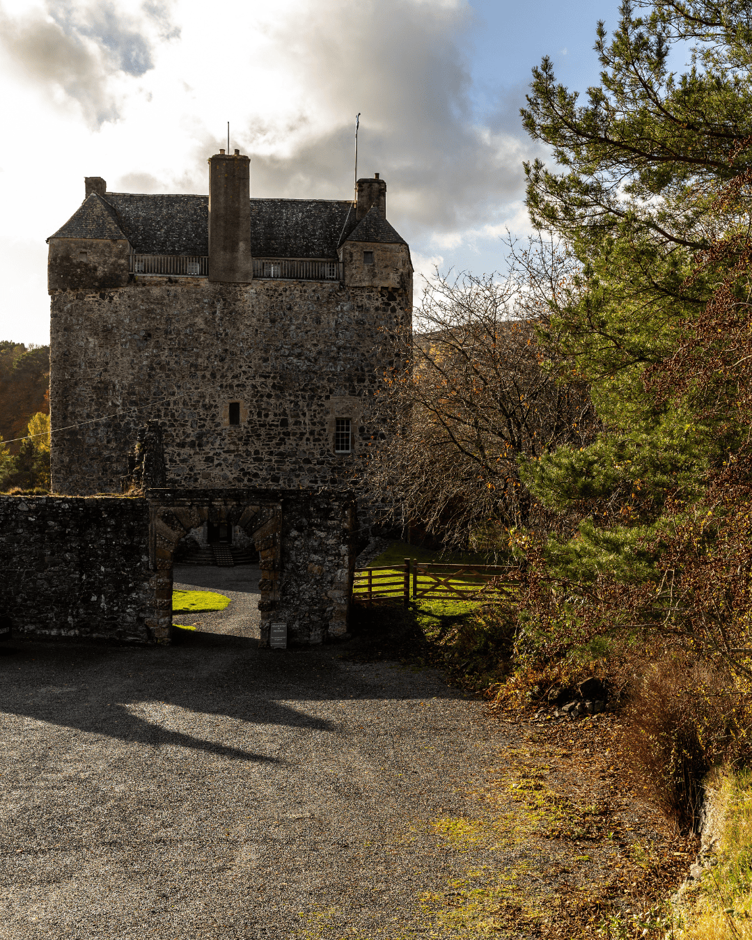 Scottish castle surrounded by autumn woodland in soft golden light